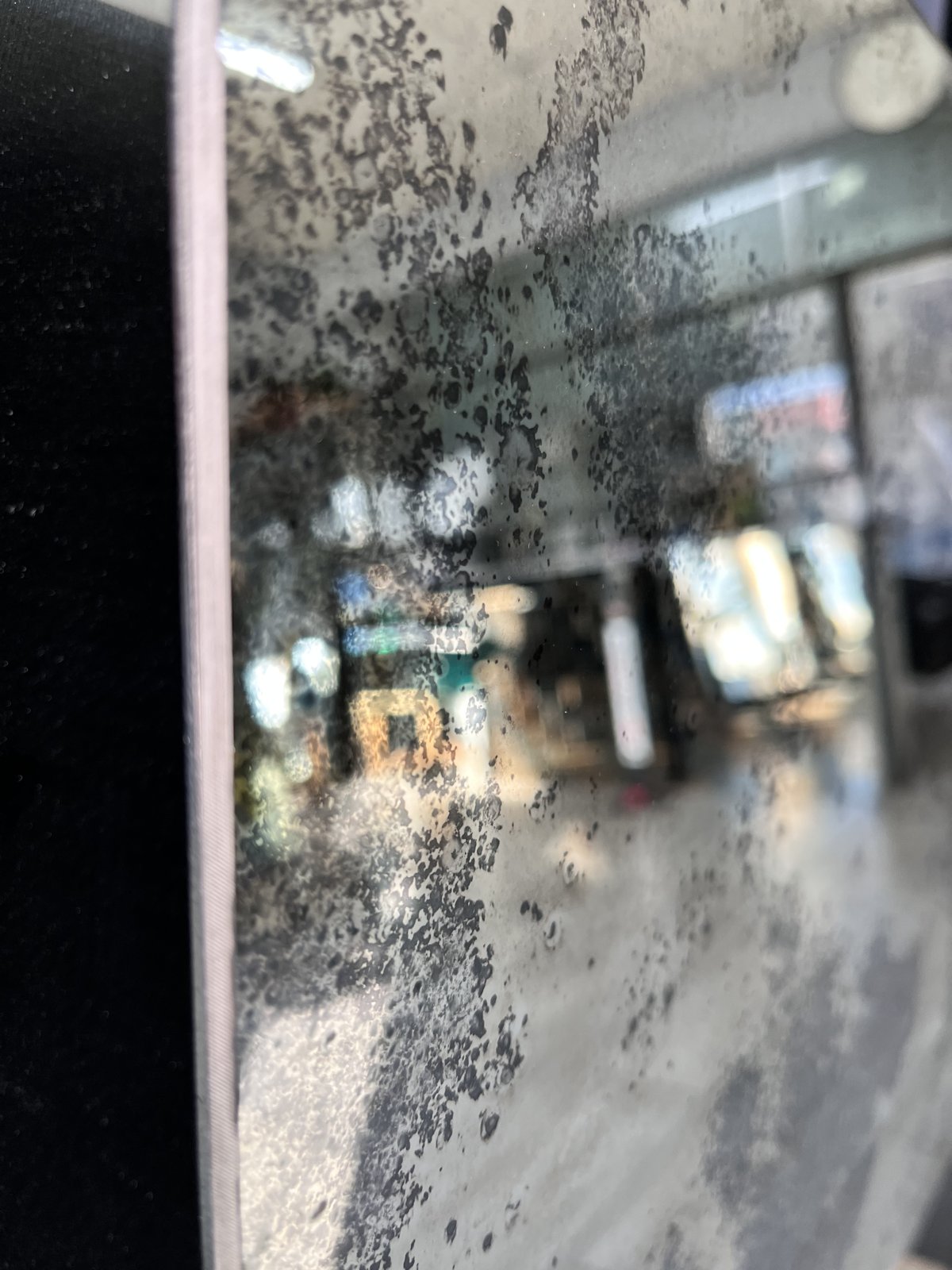 Detail of a handcrafted antique mirror showing mottled silvering